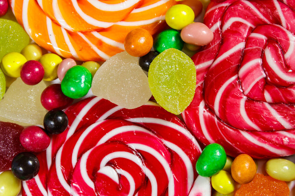 Tło kolorowych cukierków czekoladowych, lizaków, trzciny cukrowej i galaretki słodycze - Zdjęcie, obraz