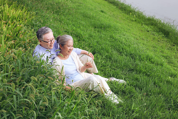 Happy old couple watching the scenery by the lake - Photo, Image