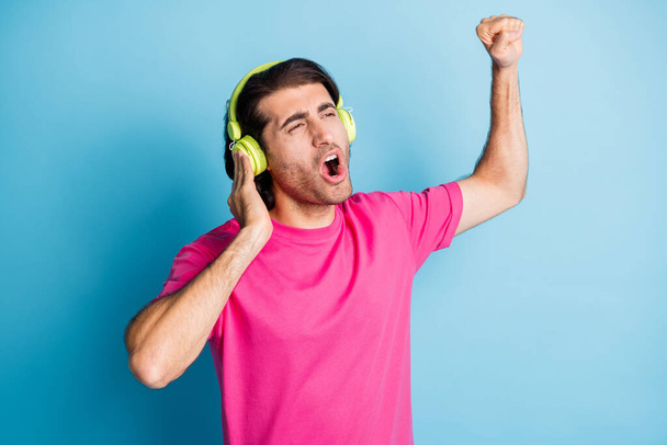 Portrait of attractive cheerful guy fan meloman enjoying listening single singing hit isolated over bright blue color background - Foto, Bild