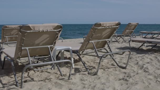 Ligstoelen gestapeld op het strand - Video