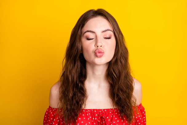 Photo portrait of funky girl sending air kiss pouted lips in red dress isolated on vibrant yellow color background - Fotoğraf, Görsel