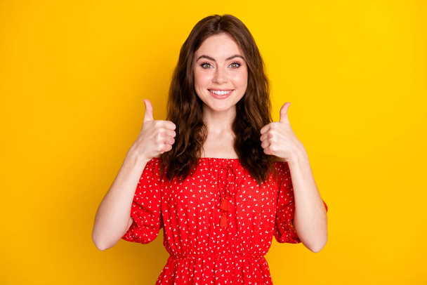 Photo portrait of curly girl in printed dress showing thumb-up sign gesture both hands isolated vibrant yellow color background - Foto, afbeelding