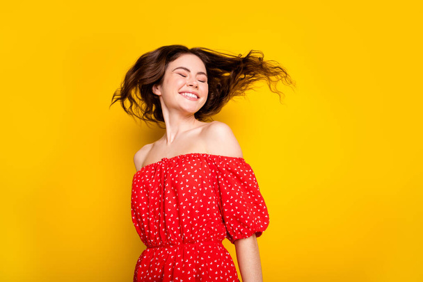 Photo portrait of dreamy girl with wavy hair in red dress dancing laughing closed eyes isolated bright yellow color background - Foto, immagini
