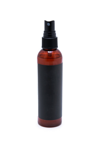 Una botella de spray negro y marrón aislada sobre un fondo blanco. - Foto, Imagen