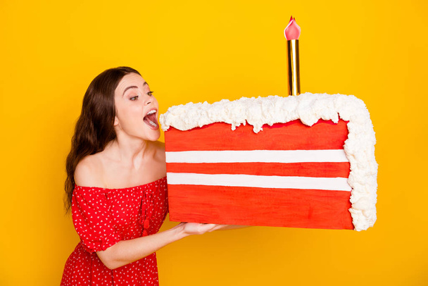 Photo of carefree positive lady open mouth look large slice of cake isolated on yellow color background - Fotoğraf, Görsel