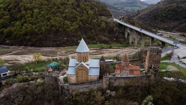 Dva středověké kostely v pevnosti Ananuri proti smaragdově zelené vodě z přehrady Jinvali, historické místo v Gruzii. Kvalitní fotografie - Fotografie, Obrázek