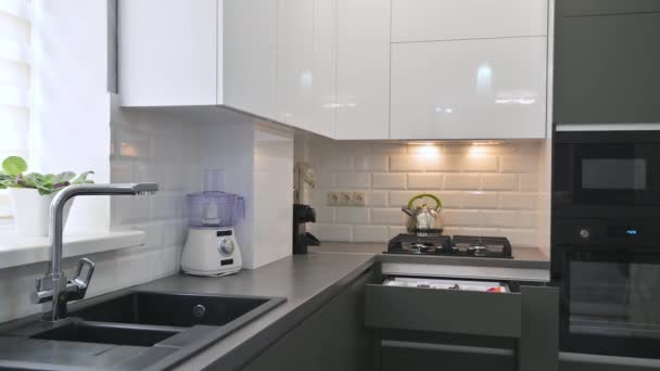 Panorama rapproché de l'intérieur moderne de la cuisine blanche et grise avec foyer rack - Séquence, vidéo