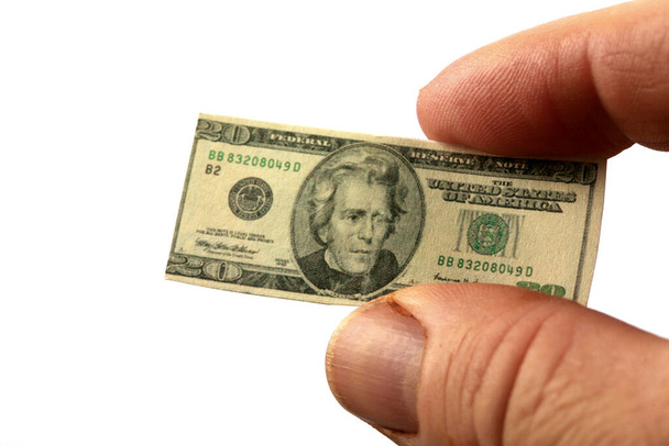 Shrinking American money. miniature twenty dollar bill held by tweezers. world wide shrinking economy. isolated on white.  - Photo, Image