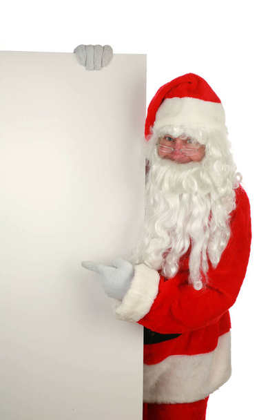 Santa Claus.  Santa Claus Isolated on white. Room for text. Santa Claus poses for his Christmas Portrait against a white wall. Clipping path. Santa says HO HO HO. Merry Christmas. Happy New Year to all. Santa holds a blank sign. - Photo, Image