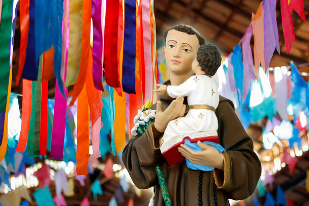 Sant'Antonio di Lisbona o Sant'Antonio de Padova e il bambino Gesù immagine cattolica con bandiere colorate giugno - Foto, immagini