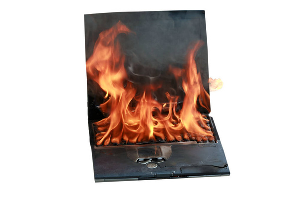 Справжній комп'ютер Lap Top повністю охоплений полум'ям вогню. Комп'ютерні пошкодження, завдані людині, так швидко спалювали Інтернет або писали щось настільки гаряче, що він буквально загорівся. Ноутбук спалює пожежну небезпеку. Комп'ютерна пожежа
.   - Фото, зображення