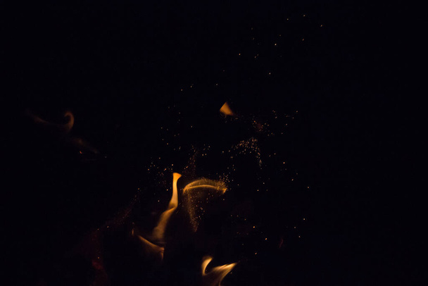 sparks of fire on a black background at night - Foto, Imagem