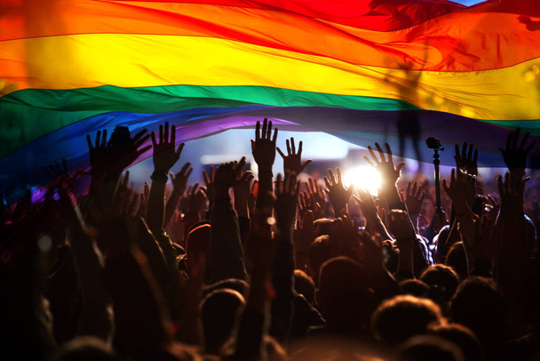 愛と寛容の象徴である虹の旗を持つゲイとレズビアンのパレードのシルエット- lgbt rights - 写真・画像