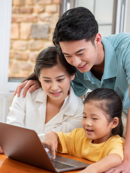 A Happy family of three using laptop - Photo, Image
