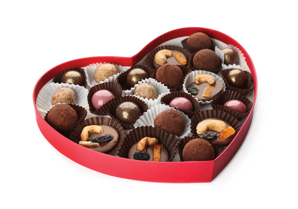 Delicious chocolate candies in heart shaped box on white background - Foto, Imagem