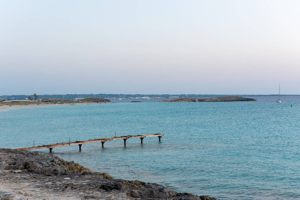 Molo na bezludnej plaży Ses Illetes na wyspie Formentera w Hiszpanii. - Zdjęcie, obraz