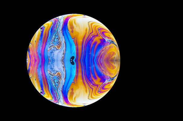 Primer plano de una burbuja abstracta de jabón que se asemeja a un planeta. Copiar el espacio sobre un fondo negro. - Foto, Imagen