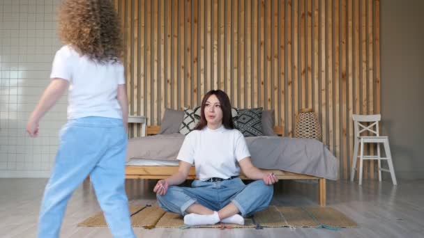 Mãe irritada senta-se em pose de ioga e olha para a filha impertinente - Filmagem, Vídeo