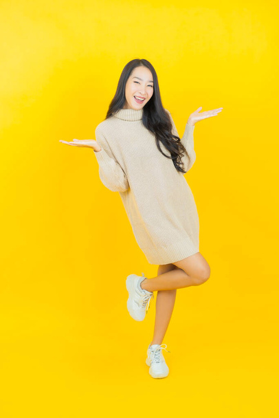 Retrato hermosa joven asiática mujer sonrisa con acción en color fondo - Foto, imagen