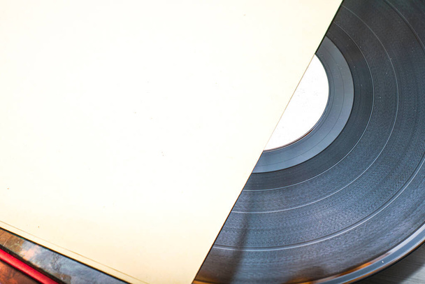 μια στοίβα από παλιούς δίσκους βινυλίου κοντά ένας από τους δίσκους είναι μισός από το φάκελο. Υψηλής ποιότητας φωτογραφία - Φωτογραφία, εικόνα