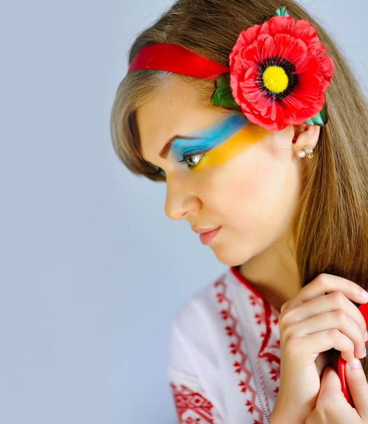 Retrato de uma mulher com maquiagem criativa bandeira ucraniana em seu rosto no traje nacional ucraniano
 - Foto, Imagem