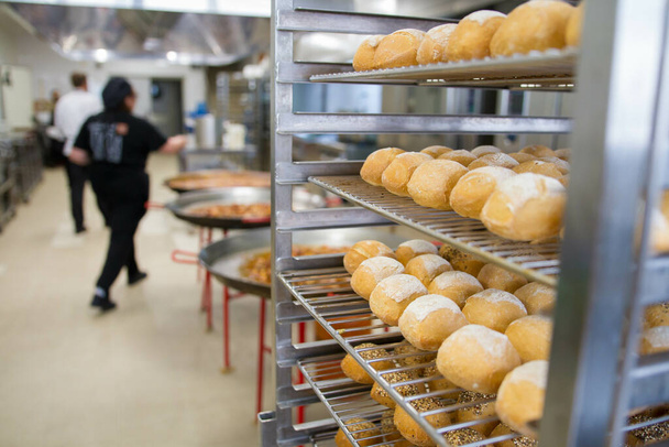 Freshly baked buns on the shelves in a kitchen - Φωτογραφία, εικόνα