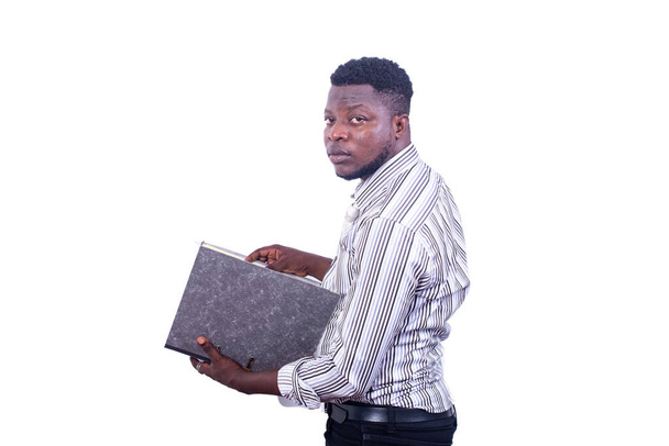 νεαρός σοβαρός επιχειρηματίας στέκεται στην άκρη κρατώντας ένα ντουλάπι αρχειοθέτησης, ενώ κοιτάζοντας την κάμερα. - Φωτογραφία, εικόνα