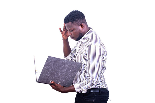 νεαρός σοβαρός επιχειρηματίας που στέκεται πλάγια διαβάζοντας τα αρχεία σε μια αρχειοθήκη στο χέρι. - Φωτογραφία, εικόνα
