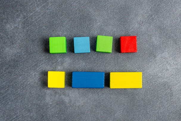 Cajas rectangulares de cubo de muestra pulidas con múltiples colores que simbolizan el desarrollo del crecimiento de la estabilidad alineado en la superficie con diferentes perspectivas limitadas por accesorios de suministros electrónicos - Foto, Imagen