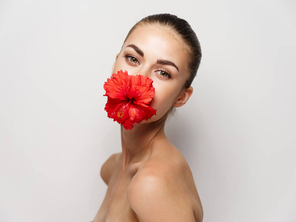 όμορφη γυναίκα κόκκινο λουλούδι διακόσμηση γυμνοί ώμοι περικοπή άποψη - Φωτογραφία, εικόνα
