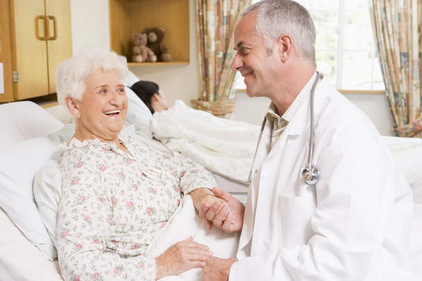Doctor Laughing With Senior Woman In Hospital - Foto, imagen