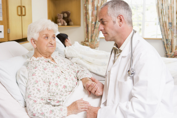 Доктор розмовляє з пацієнткою старшої жінки в лікарні
 - Фото, зображення