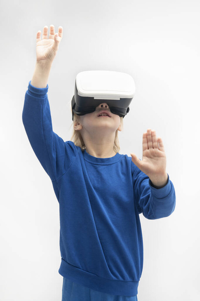 Мальчик в очках виртуальной реальности изолирован на белом фоне. VR игры. Вертикальная рамка. - Фото, изображение