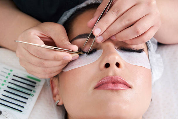 Eyelash Extension Procedure. Woman Eye with Long Eyelashes - Photo, Image