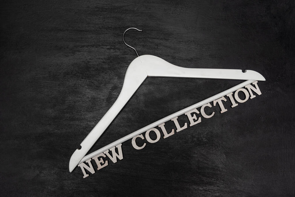 Cintre Blanc et Nouvelle Collection inscription sur fond noir. Armoire de mode - Photo, image