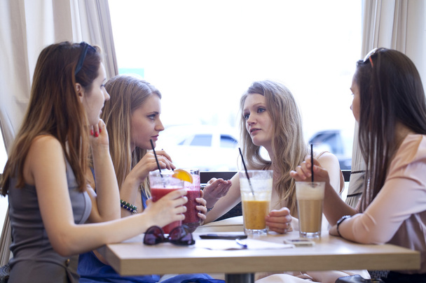 Four young girls have a rest in a summer cafe - Foto, Imagem