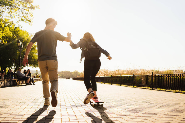 Молодая пара практикует скейтбординг на открытом воздухе - Фото, изображение