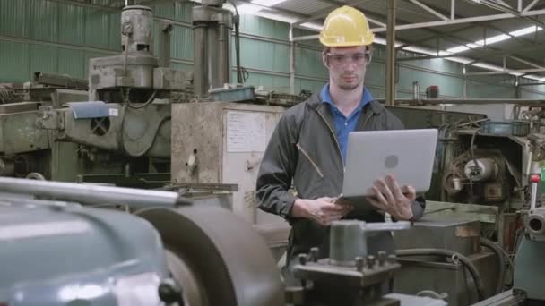 Mérnök dolgozik laptop számítógép ellenőr és karbantartó berendezések a gyárban, technikus férfi munkás ellenőrzése gépek a munkahelyen, az ipar és az üzleti, ipari koncepció. - Felvétel, videó