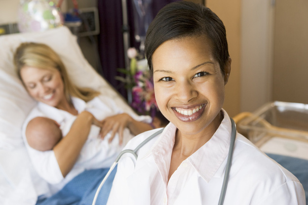 dokter staan in haar patiënten kamer, vrouw met baby - Foto, afbeelding