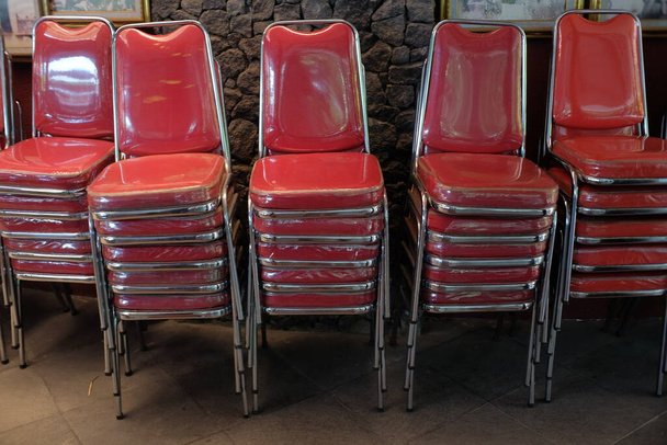 Stapel roter Stühle am Rand der Wand - Foto, Bild
