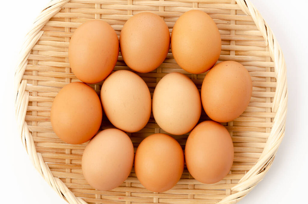 Kahverengi tavuk yumurtaları beyaz arka planda bambu eldiveni. - Fotoğraf, Görsel