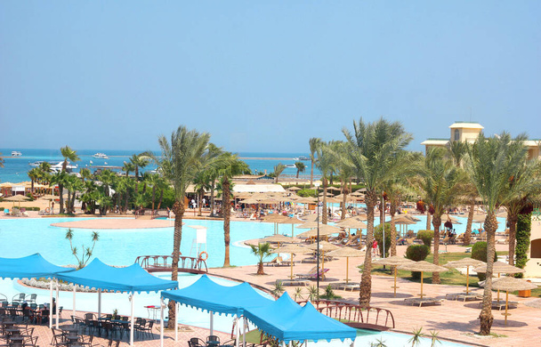 Bâtiments du complexe hôtelier palmiers et piscines sur fond de ciel et de mer, vacances et séjours en Egypte, tourisme et voyages - Photo, image