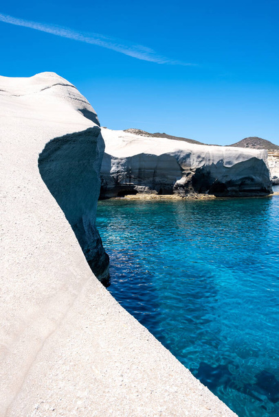 Sarakiniko Milos island, Cyclades Greece. Lunar landscape, white color rock formations, cliffs and caves, blue rippled sea and clear sky background. Summer vacation travel destination - 写真・画像