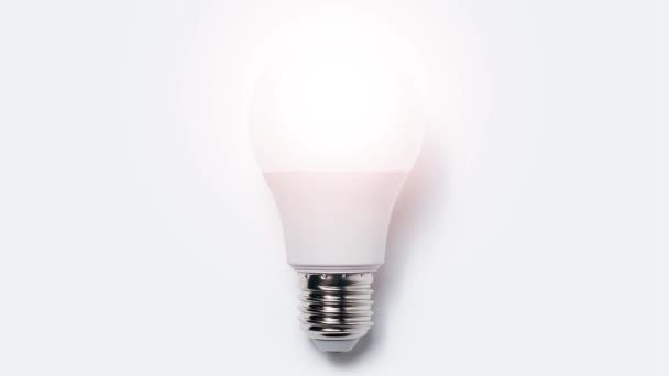Stop motion animation photography concept. Close-up of light bulb glowing on white background. - Footage, Video