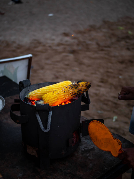 Сладкая кукуруза на угле с селективным фокусом. Вкусные закуски. Кукурузные початки на гриле. Популярная уличная кухня Индии - Фото, изображение