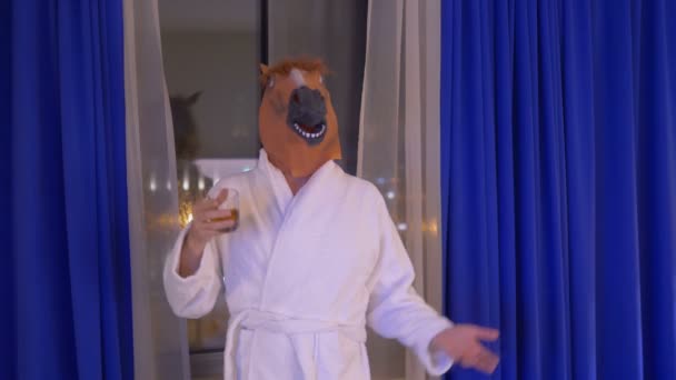 Uomo in maschera di cavallo rilassante e bere whisky dopo il lavoro in 4k slow motion 60fps - Filmati, video