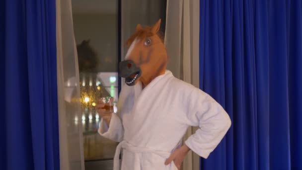 Mężczyzna w masce konia relaks i picie whisky po pracy w 4k slow motion 60fps - Materiał filmowy, wideo