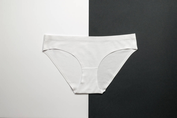 Bílé klasické dámské kalhotky na černobílém pozadí. Kontrastní sada letních šatů. Plocha. - Fotografie, Obrázek