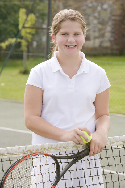 Young girl with racket on tennis court smiling - Fotografie, Obrázek
