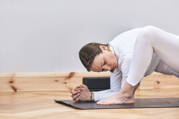Wiążąca joga pozowała, mamo Kuka. zamknięty portret latynoskiej kobiety ćwiczącej jogę z przestrzenią do reklam. - Zdjęcie, obraz